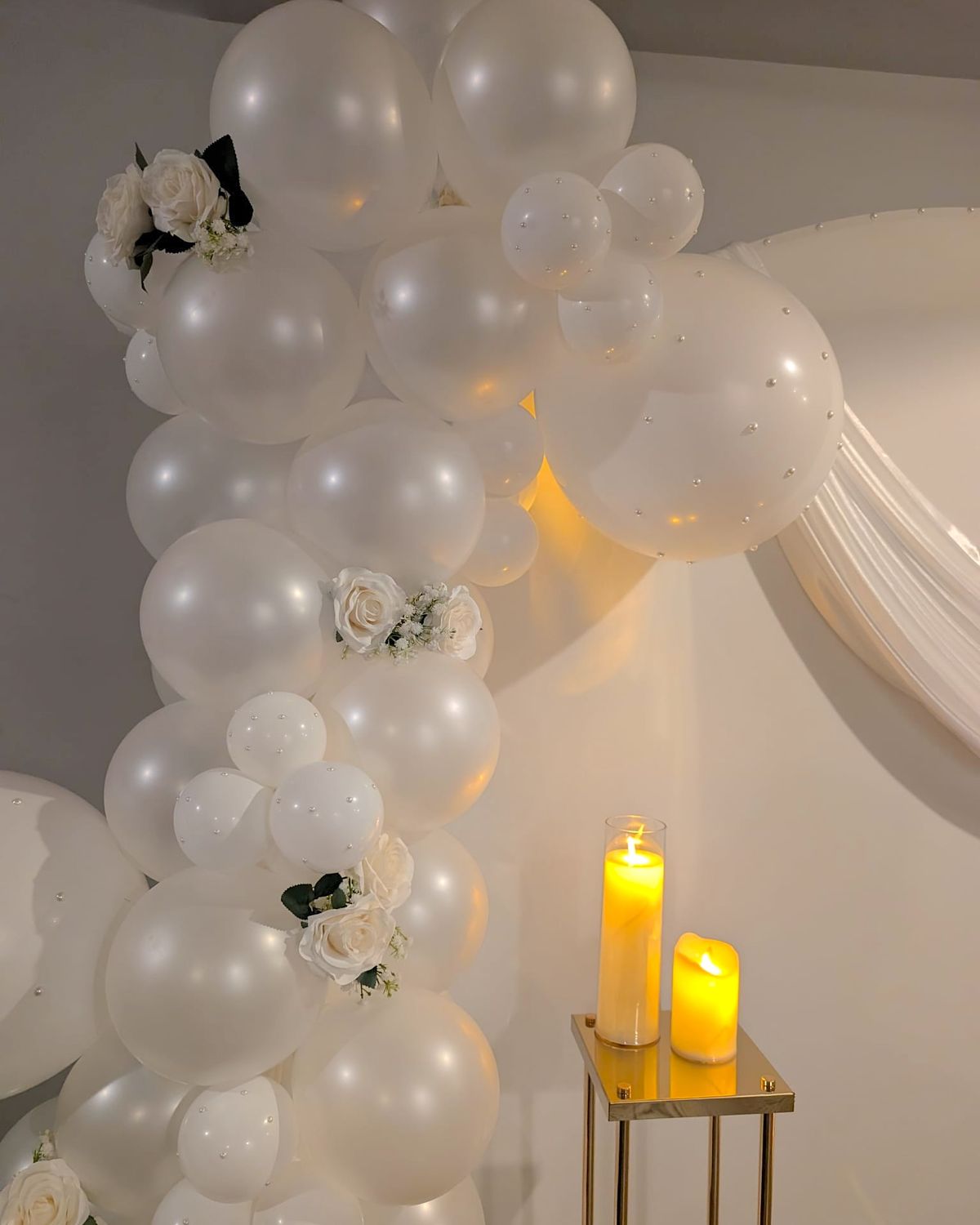 White pearl balloon garland with ivory roses and candlelight